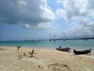 A sandy beach next to a body of water

Description automatically generated