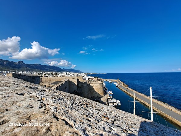 A stone wall with a dock and boats in the water

Description automatically generated