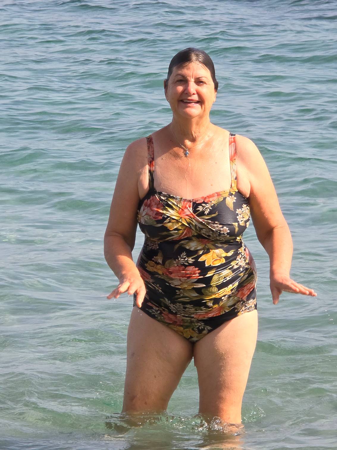 A person in a bathing suit in the water

Description automatically generated