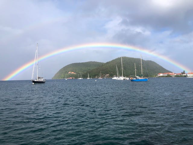A rainbow over a body of water with boats and a rainbow in the background

Description automatically generated with low confidence
